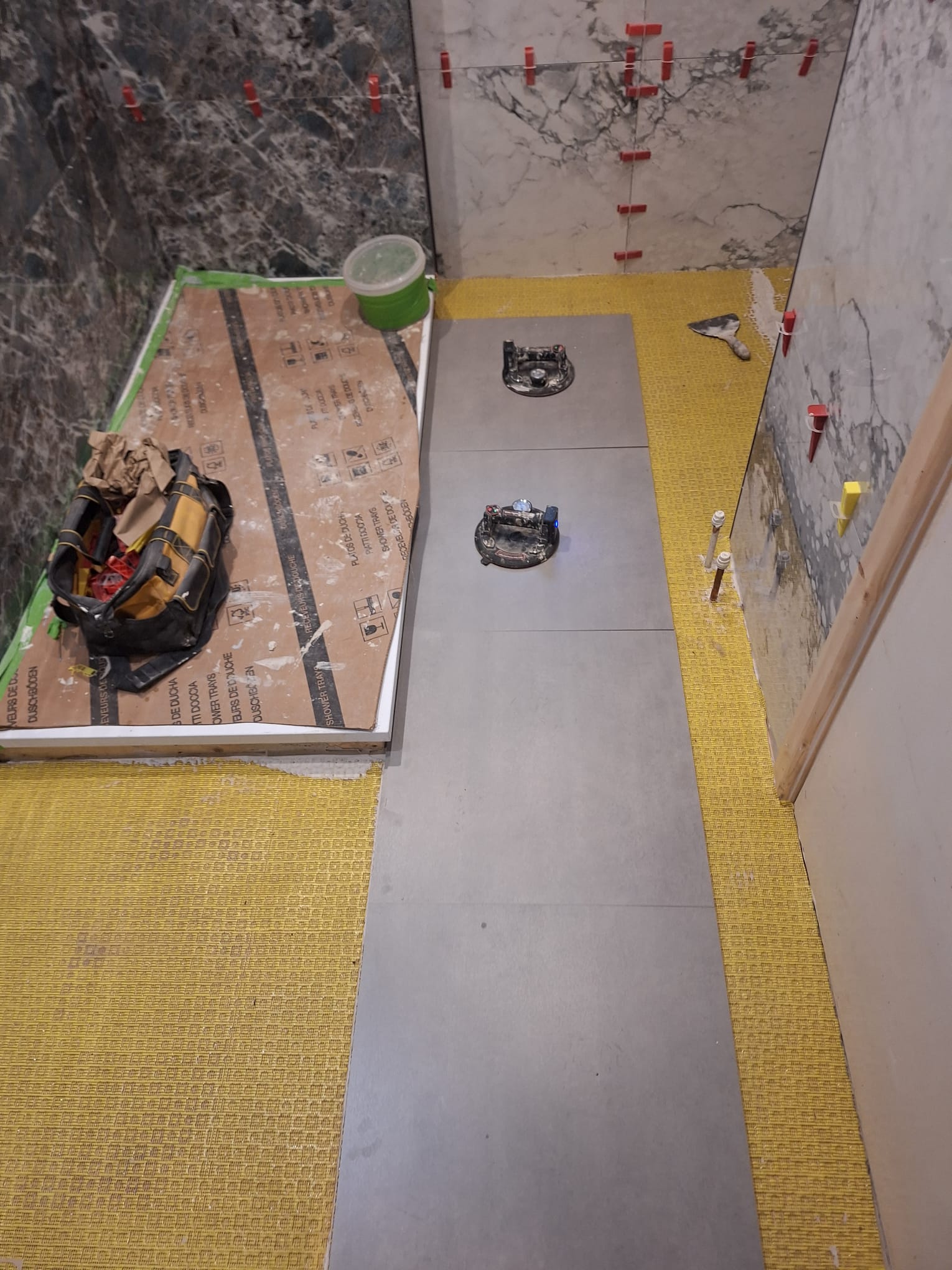 During renovation, floor tiling in progress with protective board and tools